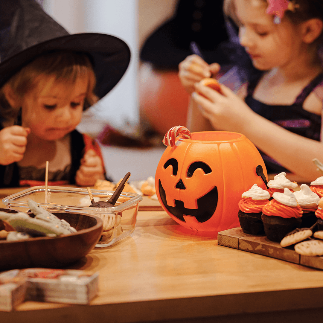 Barn dekorerar halloweenbakverk tillsammans