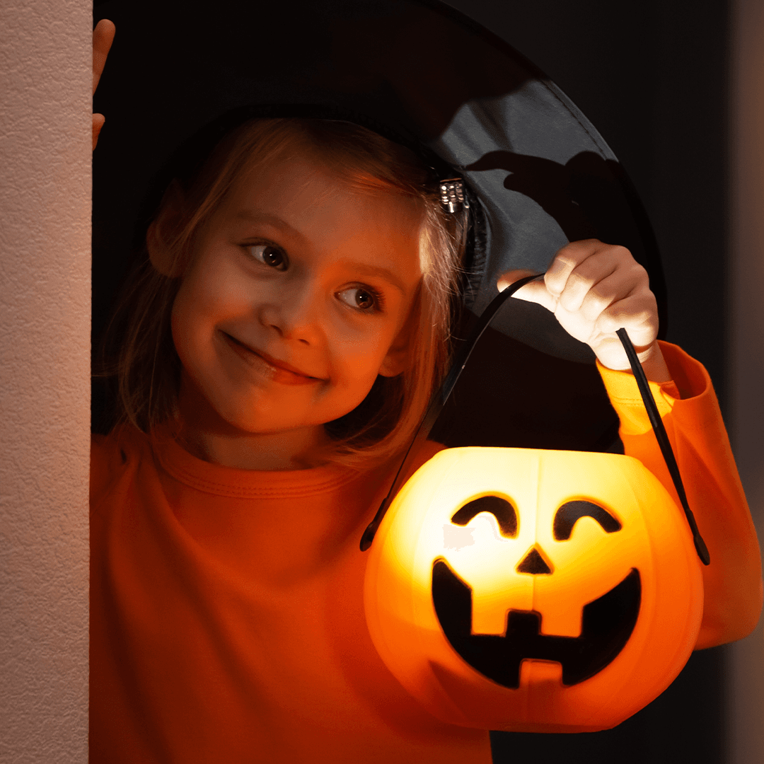 Flicka håller en pumpalykta på halloweenfest